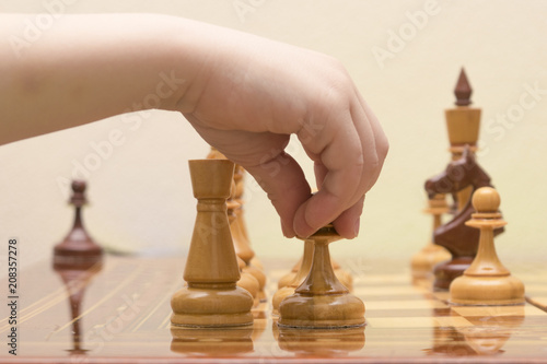 the children s hand puts a chess figure on the game field
