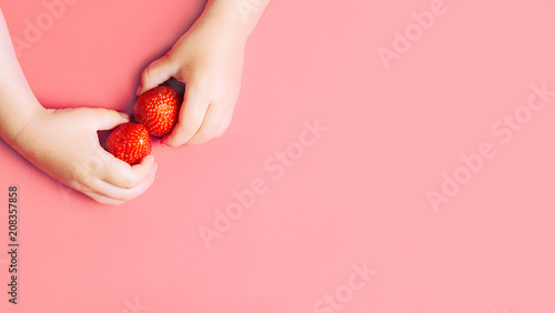 Child's hands holding strawberries