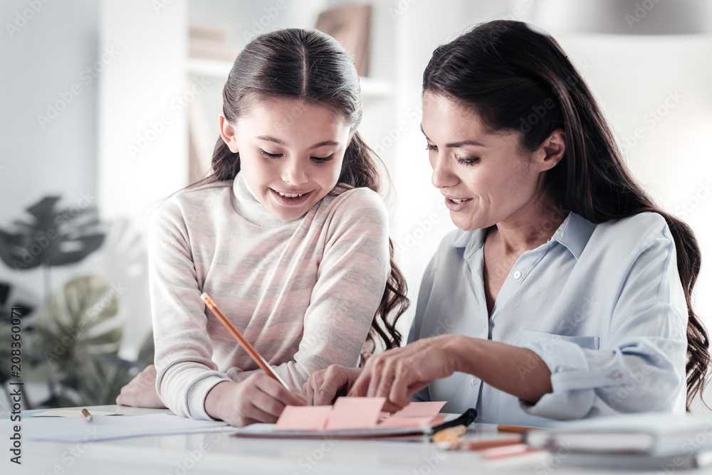 Turn on creativity. Delighted female person bowing head while looking at project work Turn on creativity. Delighted female person bowing head while looking at project work