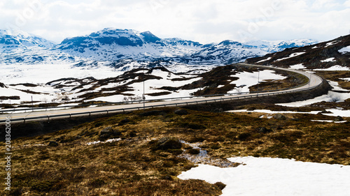 Back lit view over mountain landscape. Melting snow and ice in the terrain. Location along road E134 by the lake Kjelavatn in Telemark, Norway. photo