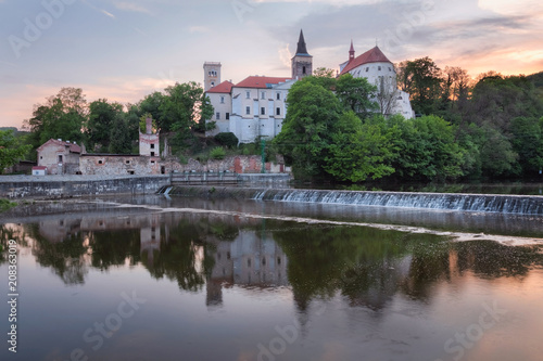 Sunset over Sazava monastery with reflection river foreground, Czech Republic