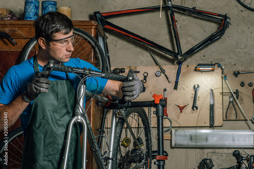 Competent bicycle mechanic in a workshop repairs a bike.