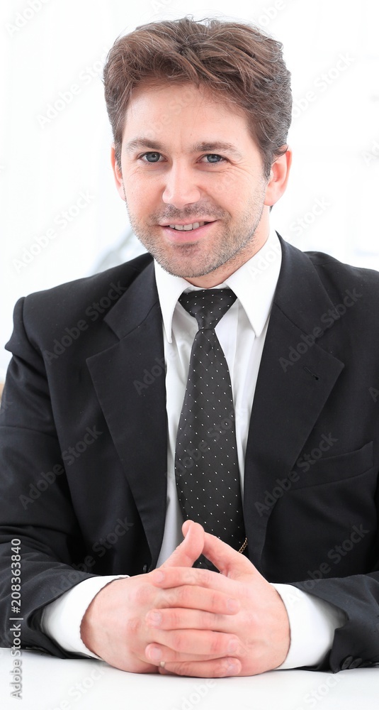 Businessman sitting at desk and working with laptop computer.
