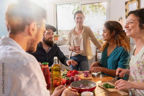 Multi-ethnic group of friends cooking lunch in the kitchen. 