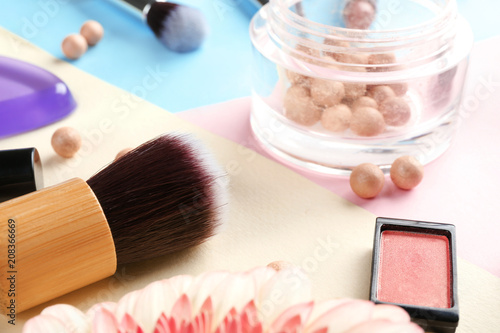 Decorative cosmetics and brush on color background, closeup
