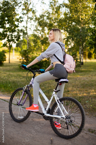 young woman in a hat with a bike in the park. Active people. Outdoors