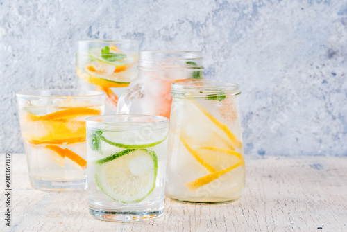 Summer healthy cocktails, set of various citrus infused waters, lemonades or mojitos, with lime lemon orange grapefruit, diet detox beverages, in different glasses light background copy space