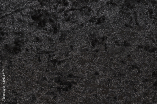 Luxurious feel of a black or dark gray velour cloth enhanced by its highly detailed texture background, featuring a lush and plush surface created from densely packed and closely woven fibers. photo