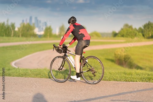 A cyclist in helmet riding a bike on a special asphalt velo road © Mak