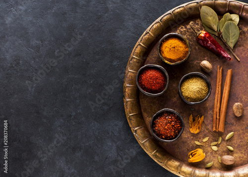 Indian spices on a vintage brass tray and copy space for text, top view