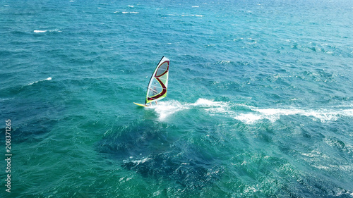 Aerial drone bird's eye view of surfer in tropical clear water beach