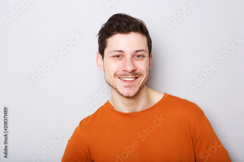 Close up smiling young man against gray background
