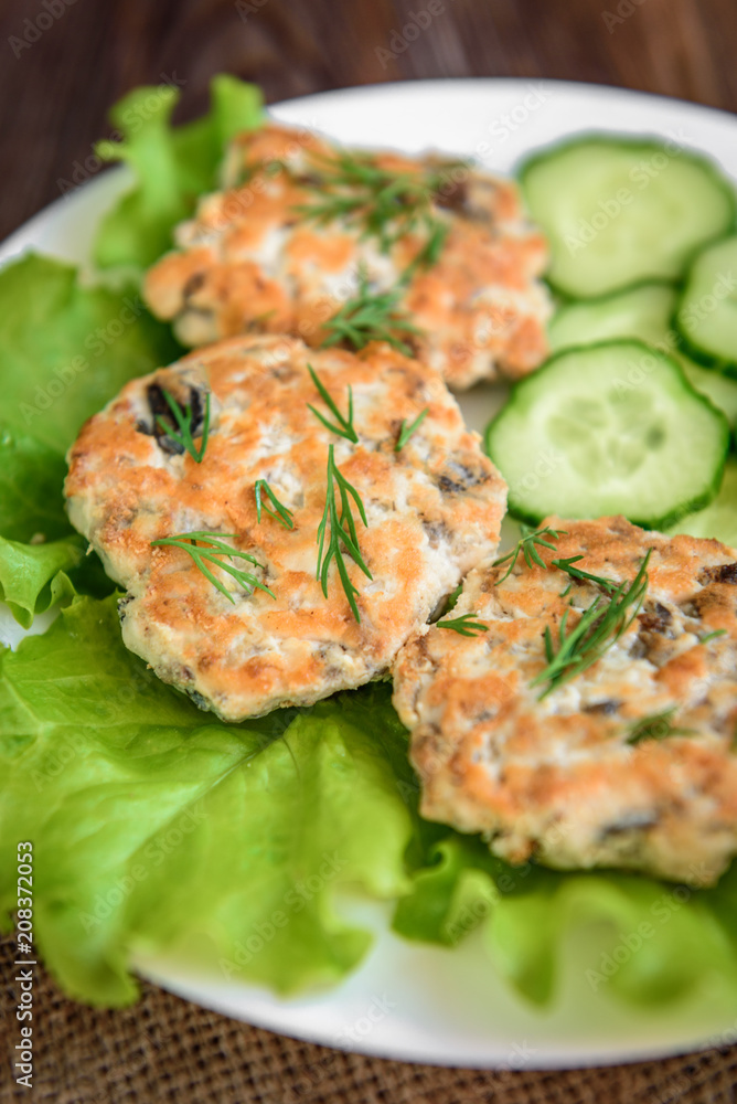 Homemade chicken and mushroom cutlets with salad, dill and cucumbers on dark wooden background. Healthy dinner or lunch. Homemade chicken and mushroom cutlets with salad, dill and cucumbers on dark wooden background. Healthy dinner or lunch.