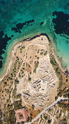 Aerial drone bird's eye view of iconic temple of Apollo on top of Kolona hill with only one pillar left standing, Aigina island, Saronic gulf, Greece