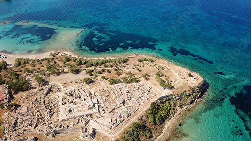 Aerial drone bird's eye view of iconic temple of Apollo on top of Kolona hill with only one pillar left standing, Aigina island, Saronic gulf, Greece photo