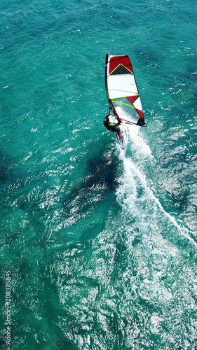 Aerial drone bird's eye view photo of competition surfers in tropical wavy clear waters