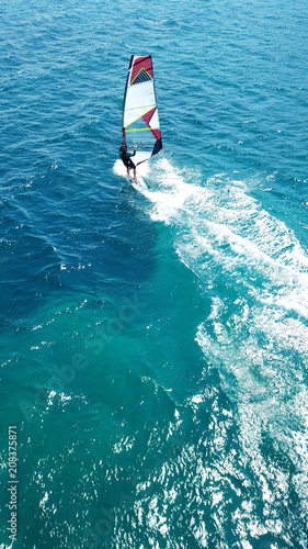 Aerial drone bird's eye view photo of competition surfers in tropical wavy clear waters