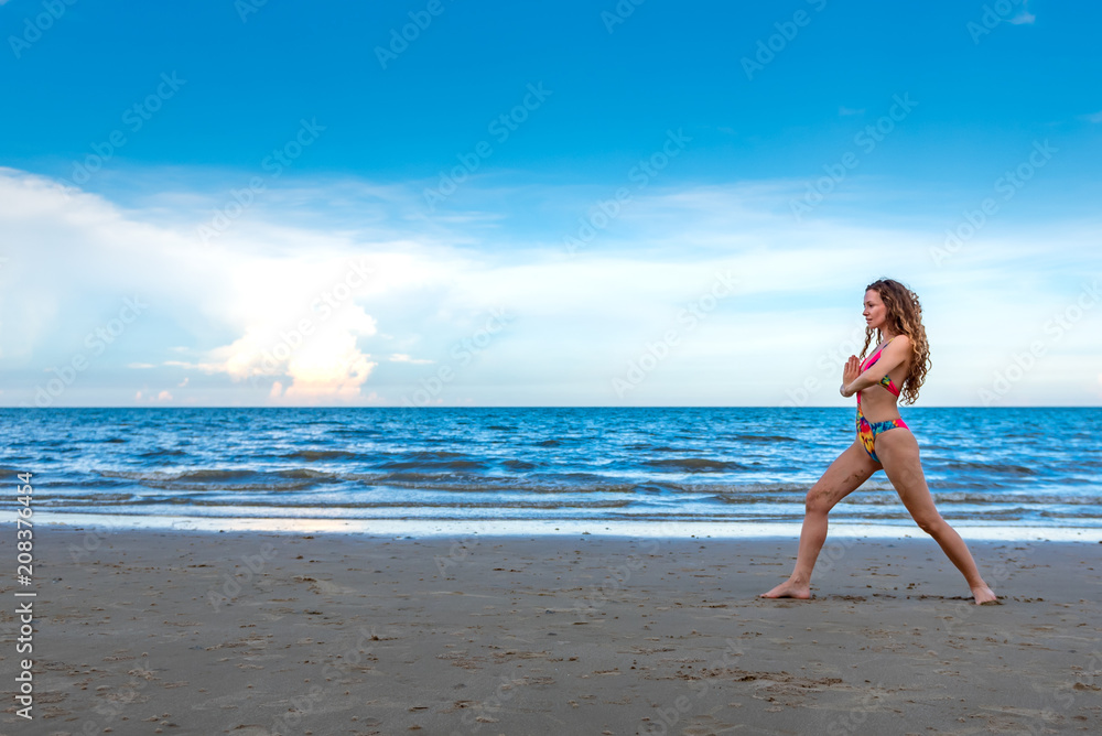 oung healthy woman with blonde curly hair doing yoga on the beach, heathy and relaxing concept. oung healthy woman with blonde curly hair doing yoga on the beach, heathy and relaxing concept.