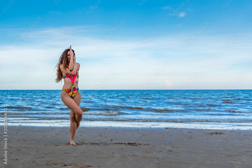oung healthy woman with blonde curly hair doing yoga on the beach, heathy and relaxing concept. oung healthy woman with blonde curly hair doing yoga on the beach, heathy and relaxing concept.