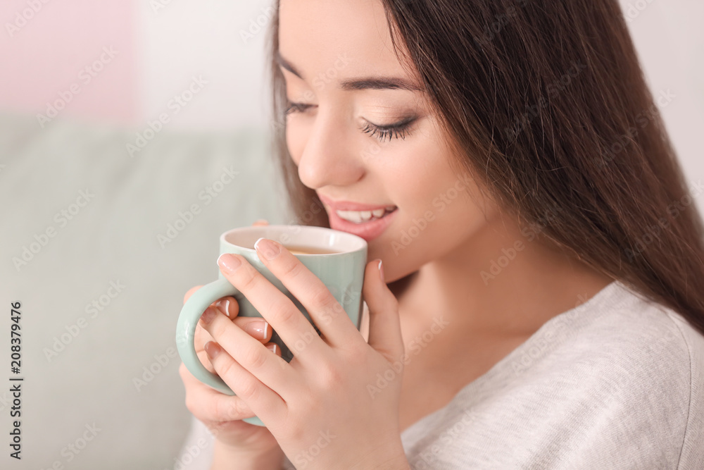 Beautiful young woman with cup of hot tea at home Beautiful young woman with cup of hot tea at home