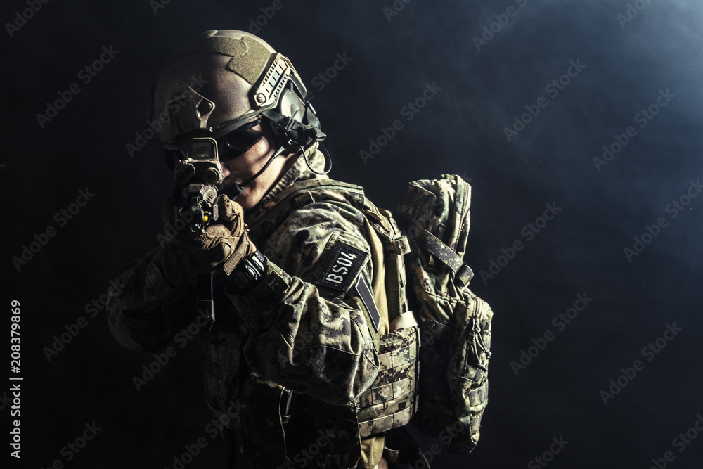 Special forces soldier with rifle on dark background