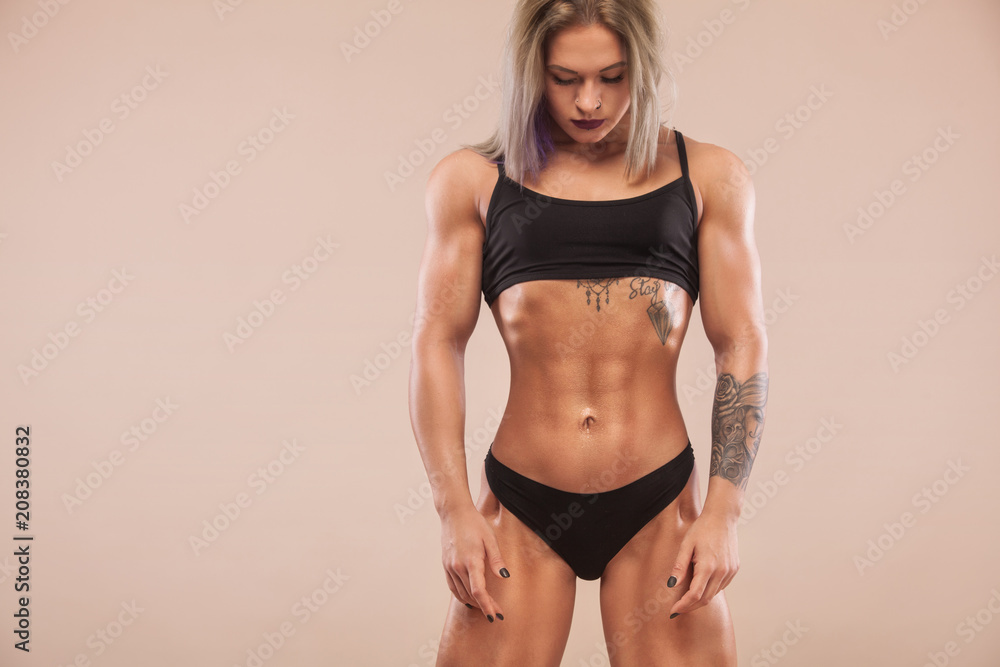 Φωτογραφία Muscular young fitness sports woman with strong fit body on light background