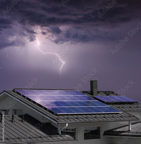 House with solar panels in thunderstorm