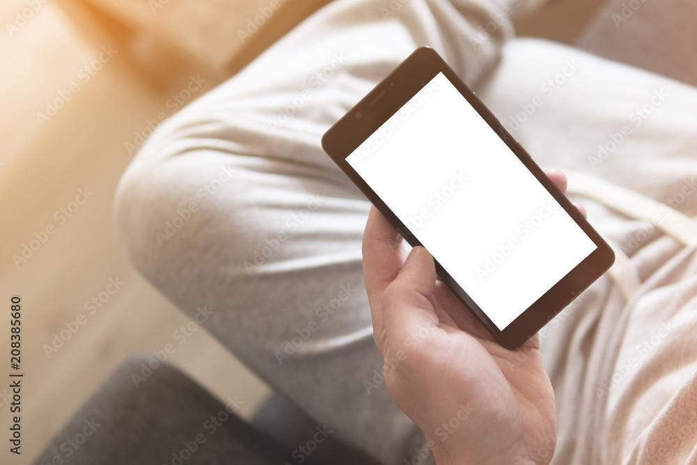 Person holding blank screen mobile phone while sitting Person holding blank screen mobile phone while sitting
