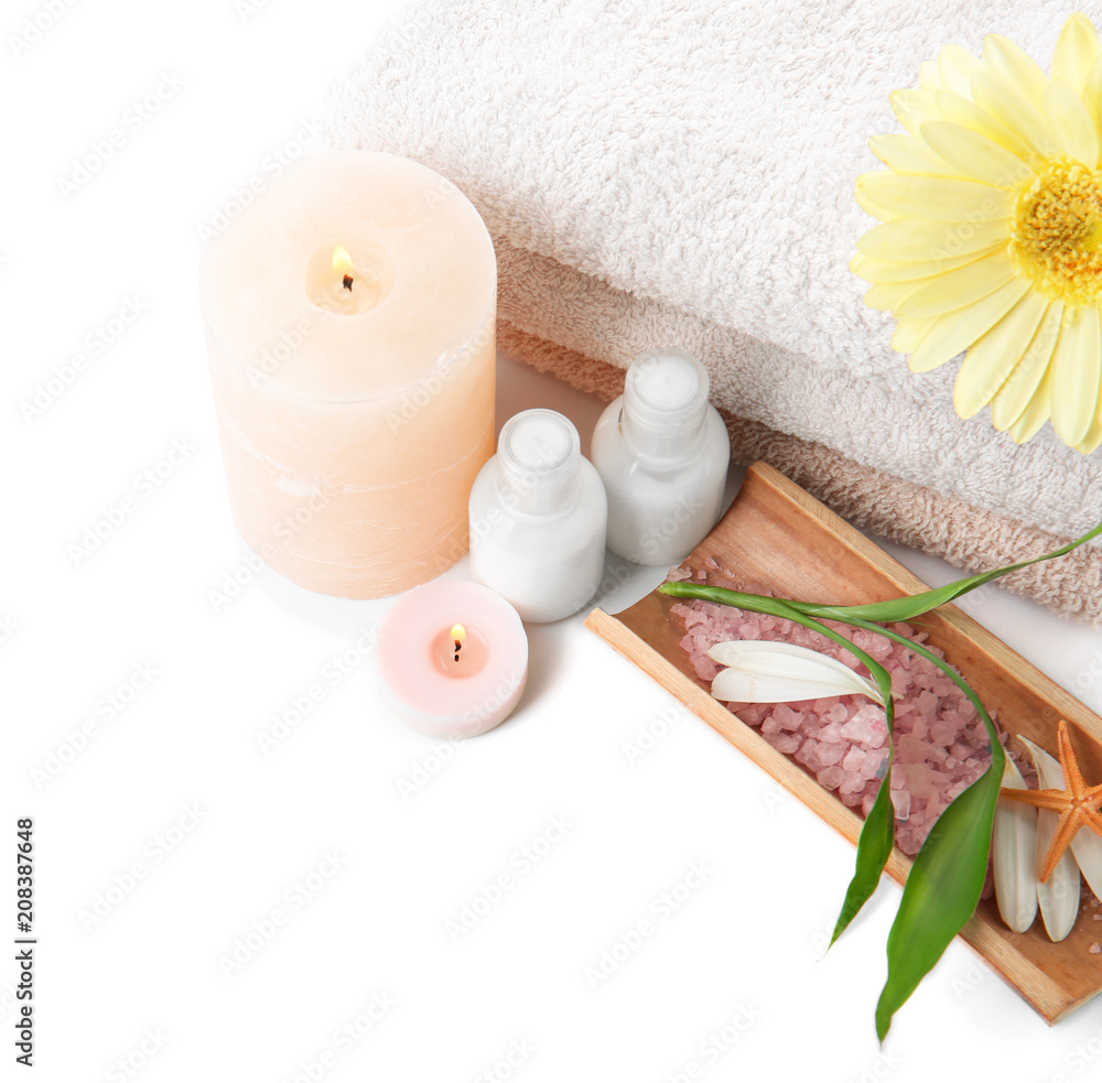 Spa composition with candles and lotion in bottles on white background
