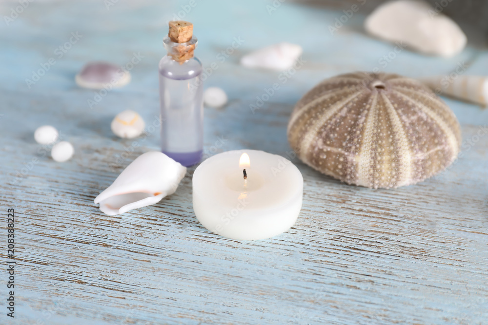 Beautiful spa composition with sea shells and burning candle on wooden background Beautiful spa composition with sea shells and burning candle on wooden background
