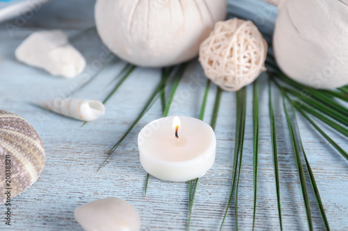 Beautiful spa composition with sea shells and burning candle on wooden background