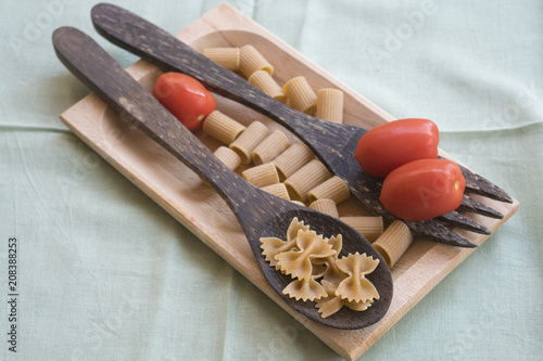 Cuadro en lienzo wholemeal pasta on a wooden ladle and fresh tomatoes