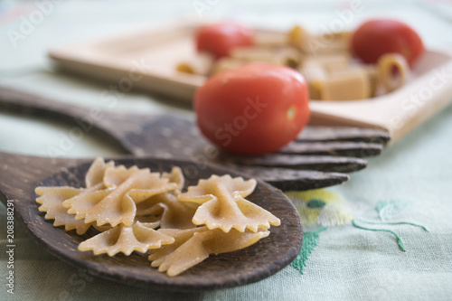 Принти на полотні wholemeal pasta on a wooden ladle and fresh tomatoes