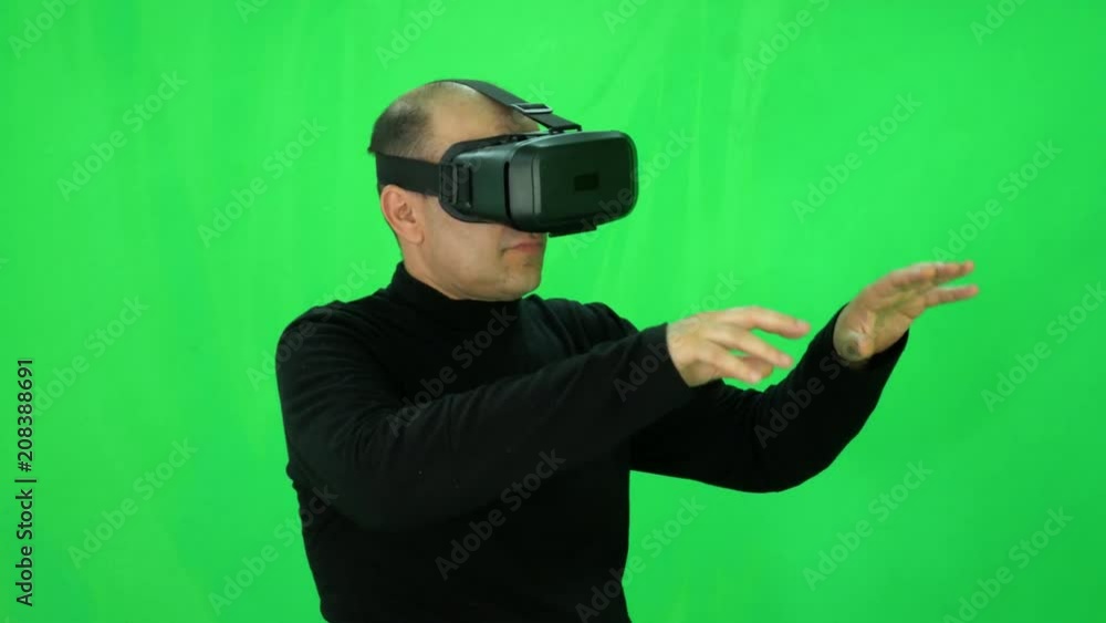 Close-up of adult man who explores virtual reality world by helmet green-screen Close-up of adult man who explores virtual reality world by helmet green-screen
