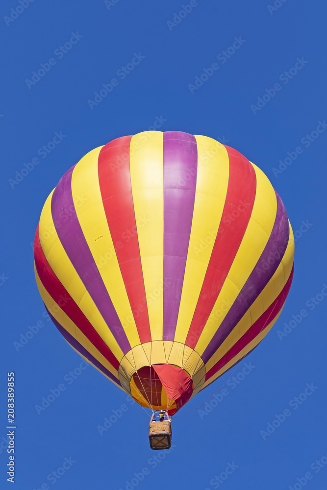 Naklejka premium Balon na ogrzane powietrze unosi się wysoko nad
