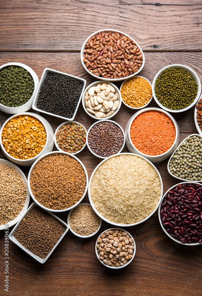 Uncooked pulses,grains and seeds in White bowls over wooden background. selective focus