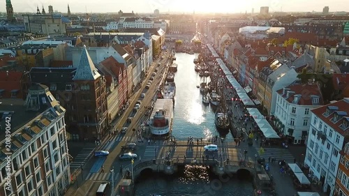 Backlight sunset footage from Copenhagen, Denmark. bridge in Nyhavn New Harbour canal and entertainment district. Aerial Video footage view from the top. forward movement. Sunset golden time light