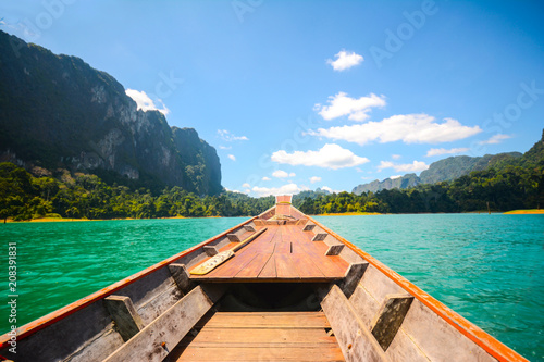 Traditional Thai long tail boat on the lake with mountains and rainforest in the back. At Ratchapruek Dam, Khao Sok National Park, Surat Thani © jakrin1976