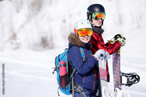 Photo of sports woman and man with snowboard on vacation