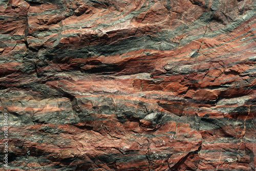 background, texture - rough surface of cliff from jasper, natural stone with a red tint