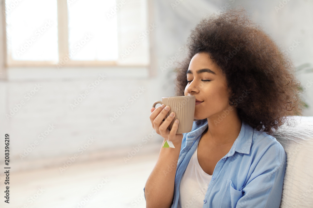 Beautiful African-American woman drinking tea at home Beautiful African-American woman drinking tea at home