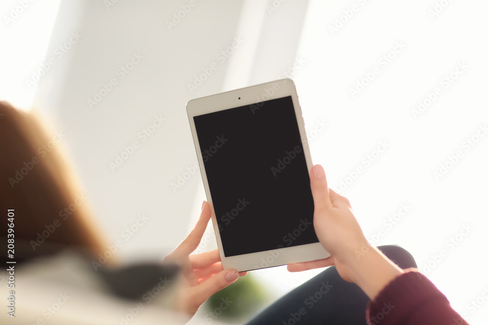 Young woman using tablet while resting at home