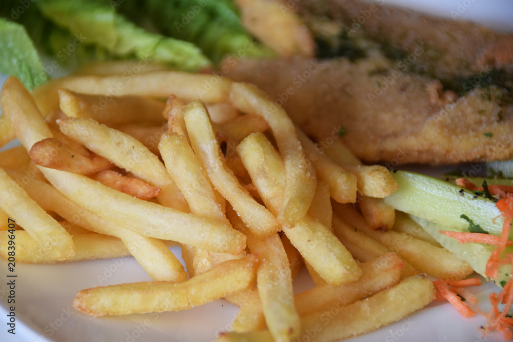 fries and a salad of fresh cucumber and grated carrot fried fish fries and a salad of fresh cucumber and grated carrot fried fish