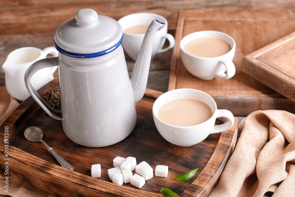 Composition of aromatic tea with milk on wooden board Composition of aromatic tea with milk on wooden board