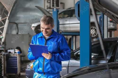 Male mechanic with clipboar...