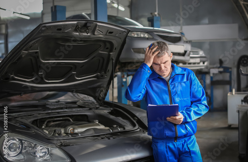 Male mechanic with clipboar...