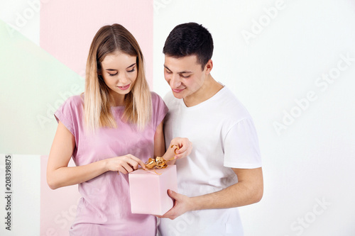 Young woman opening gift bo...