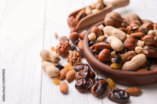 Fototapeta Naklejka Na Ścianę i Meble -  Kitchenware with different nuts and dried fruits on wooden table