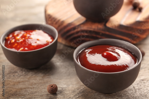 Delicious barbecue sauces in bowls on table