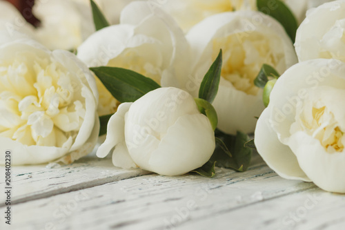 Bouquet of white peonies on the old white wooden boards